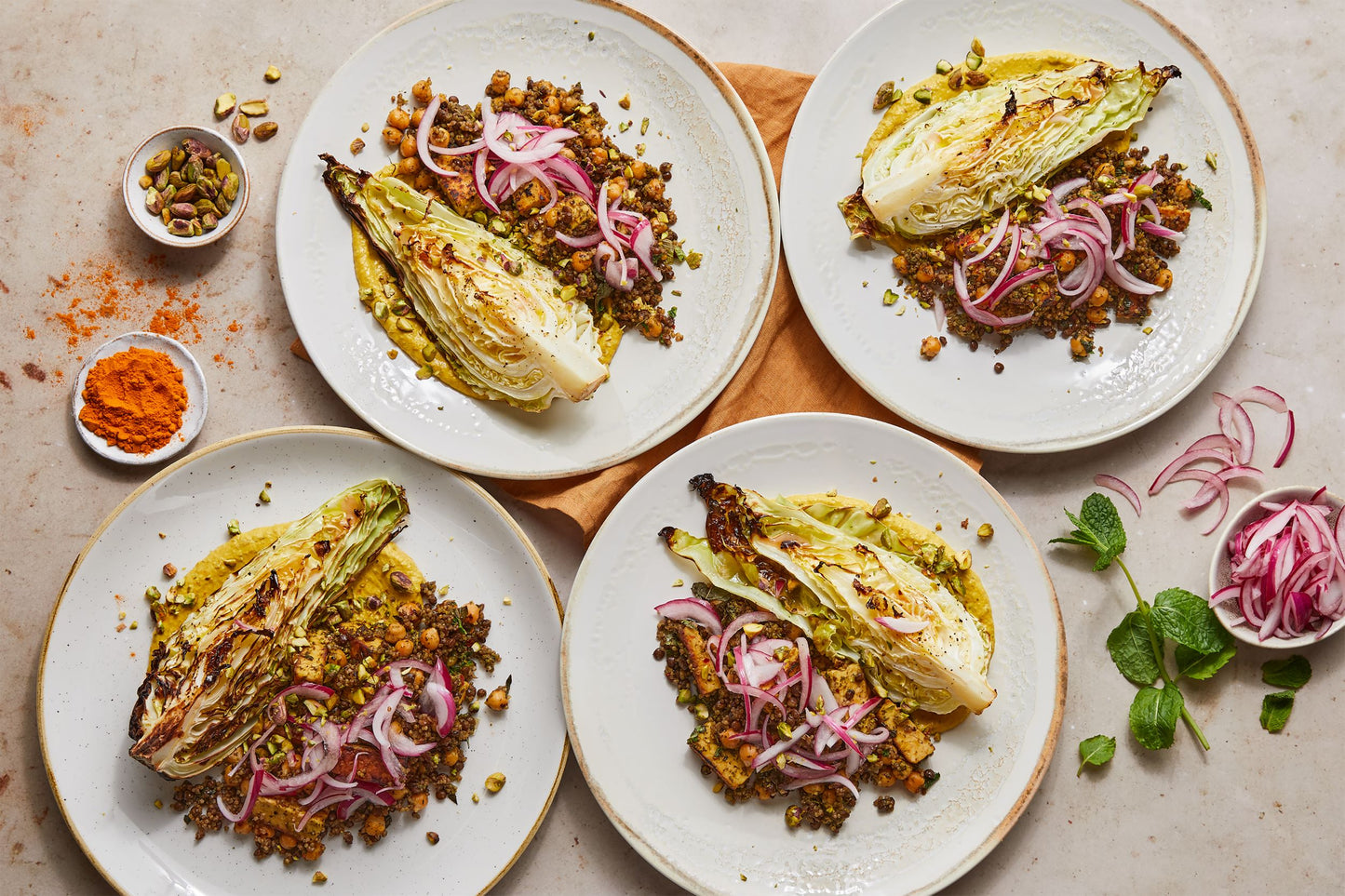 Plates of lentil and quinoa with charred cabbage, pickles and tahini yoghurt