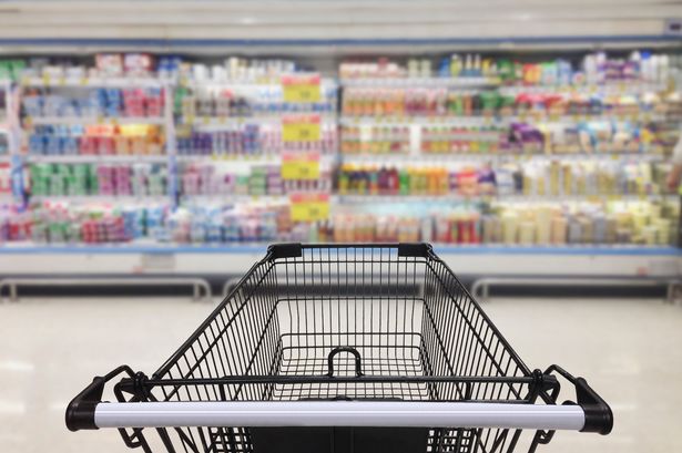 Shopping trolley in front of supermarket shelves