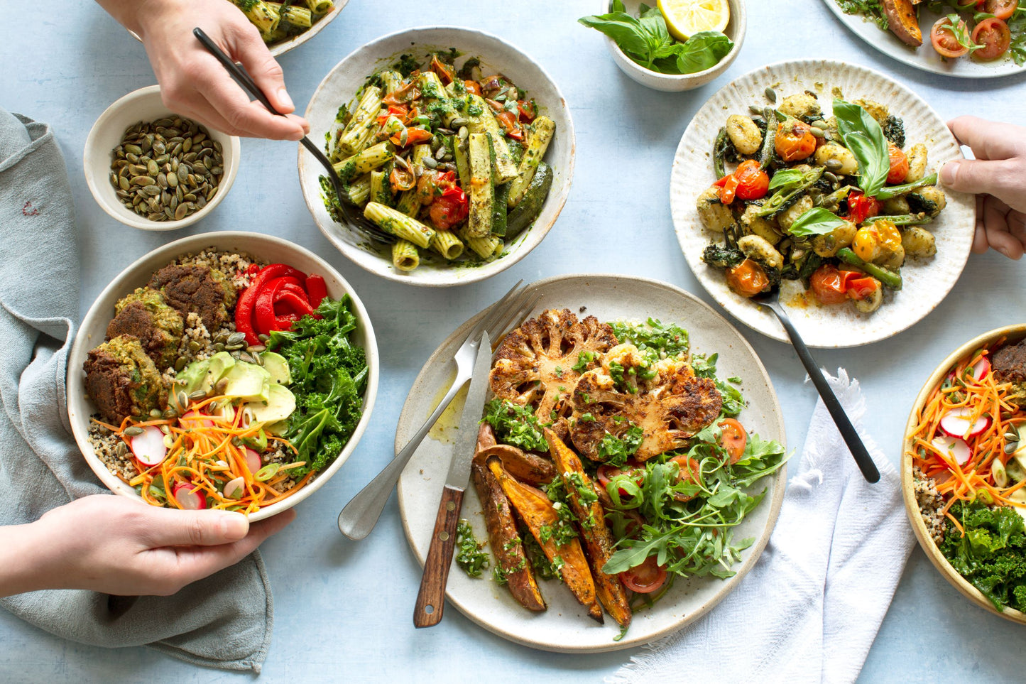 Table of several plant-based dishes including quinoa and falafels