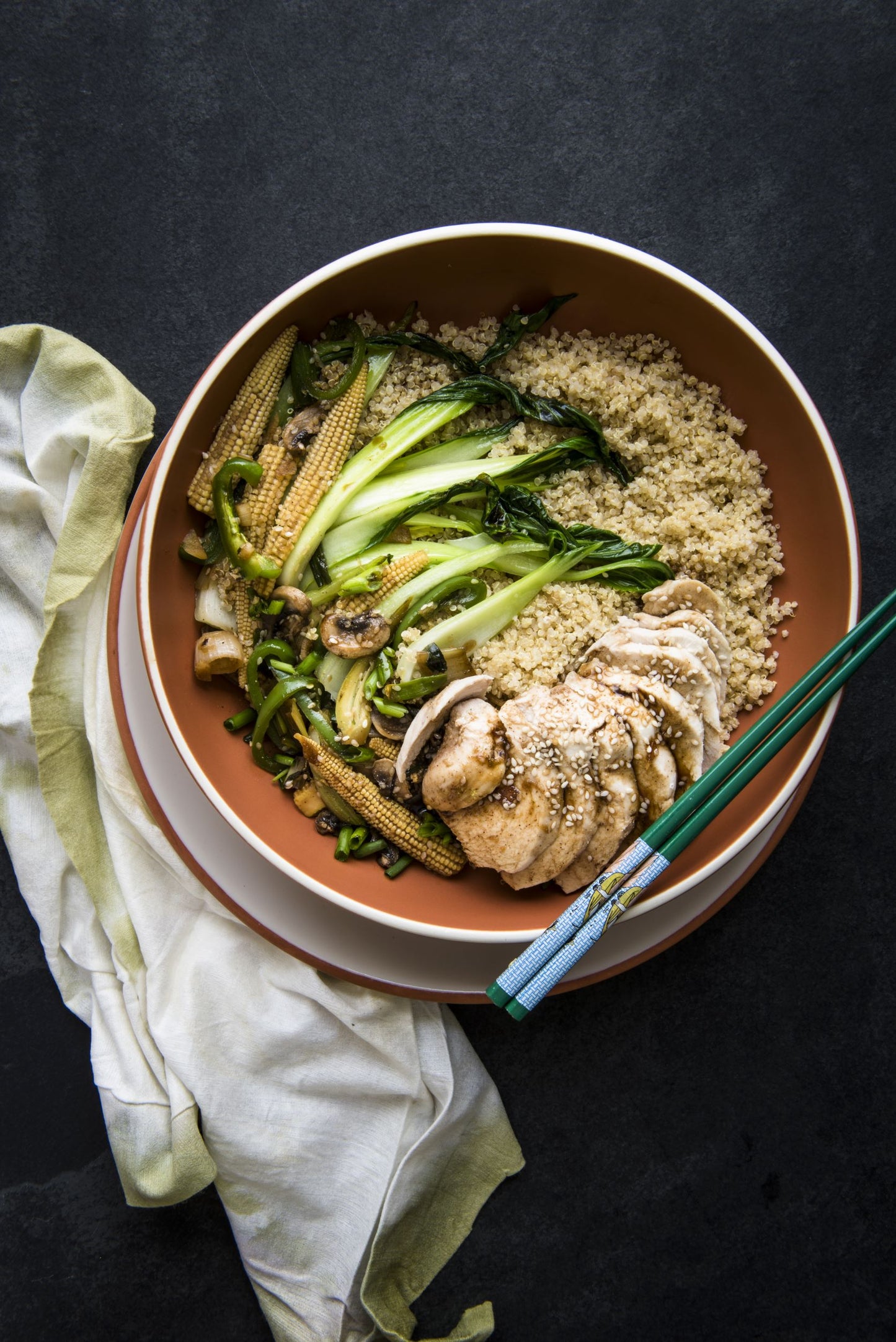 Bowl of quinoa topped with chicken and Asian inspired vegetables