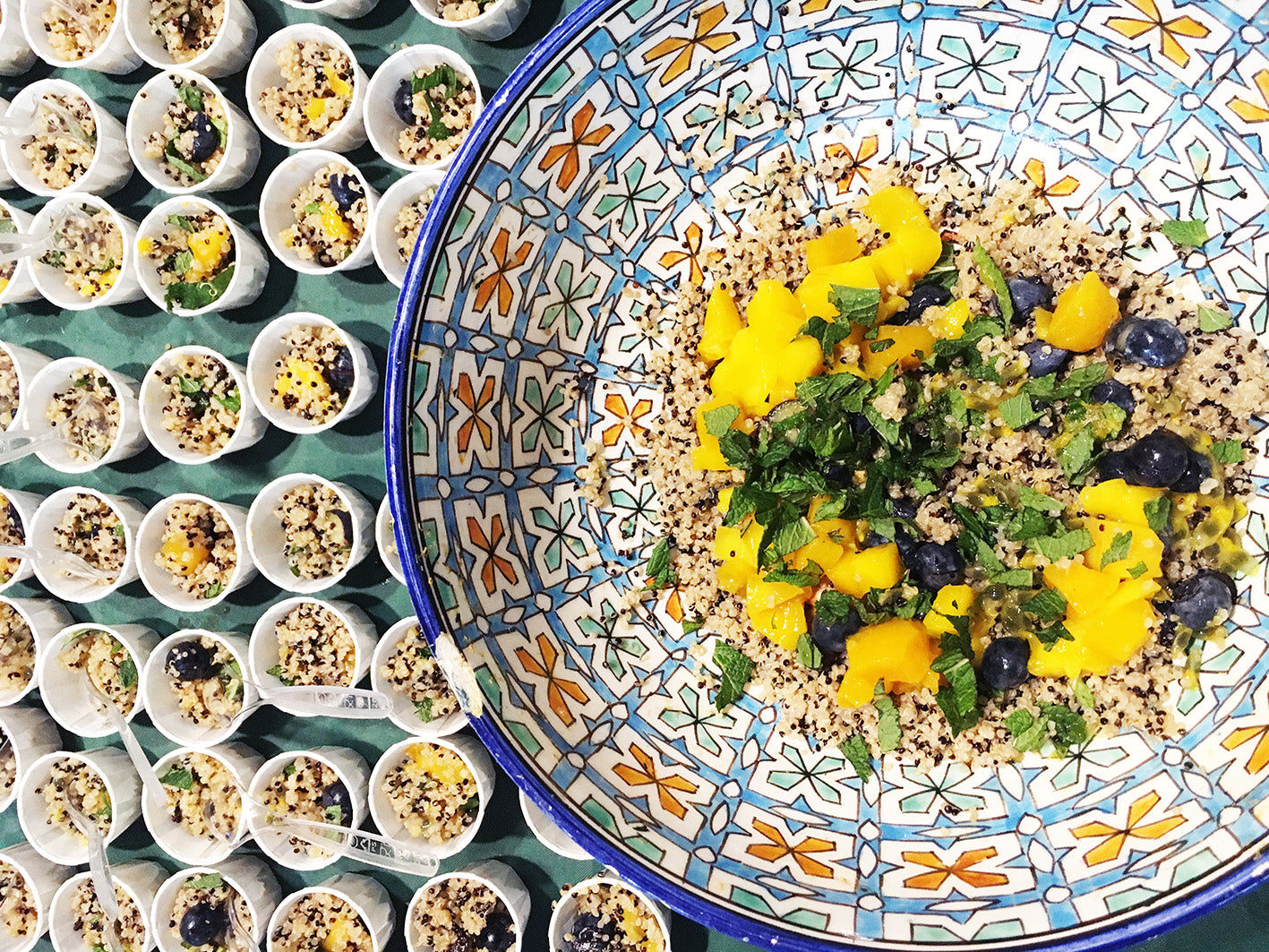 Small post of quinoa fruit salad next to a bowl of quinoa fruit salad