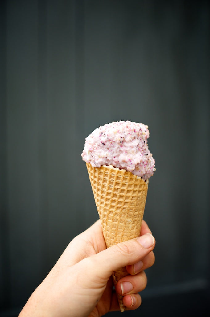 hand holding an ice cream cone with a scoop of quinoa ice cream