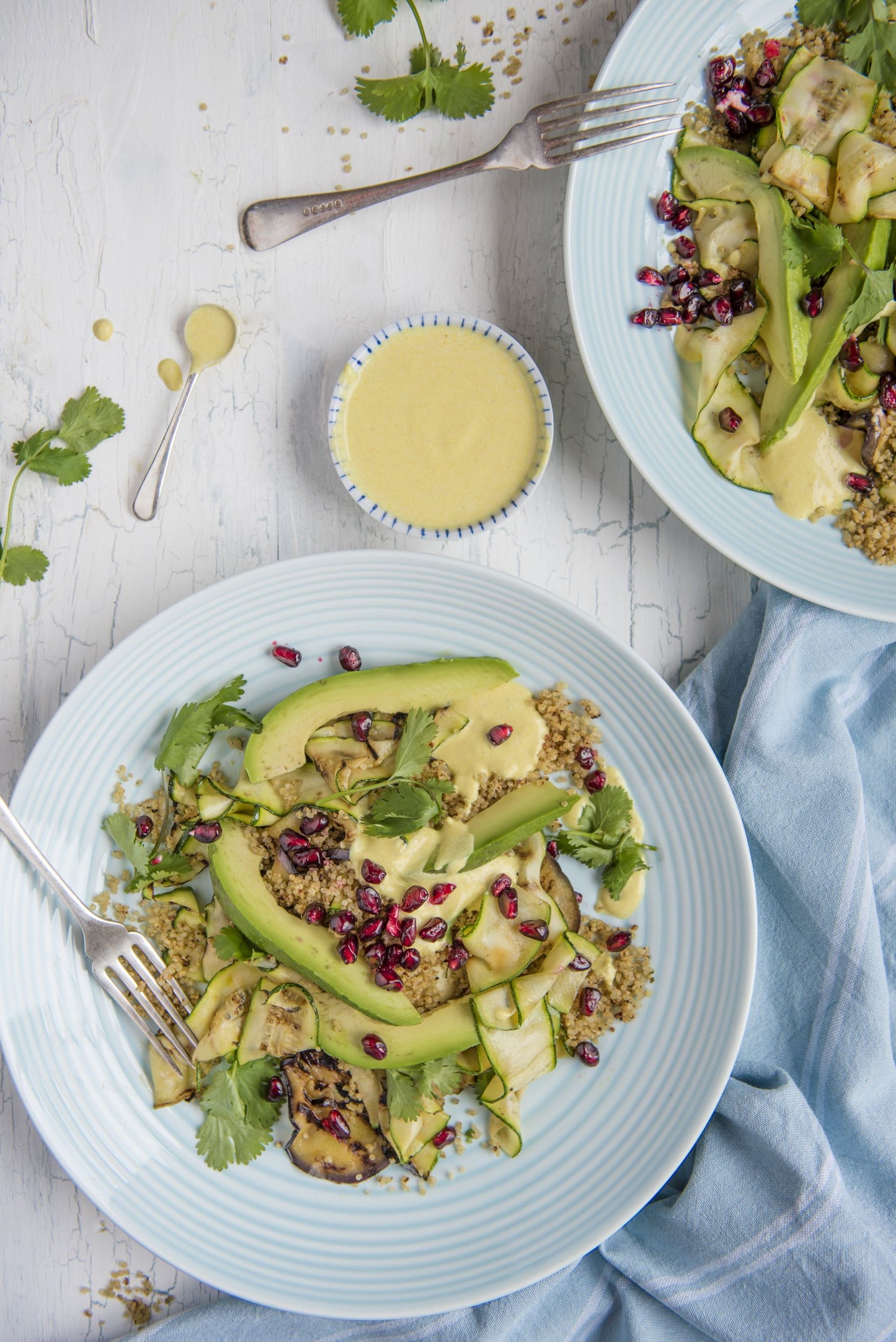 Two plates of crispy quinoa salad with aubergine and avocado slices