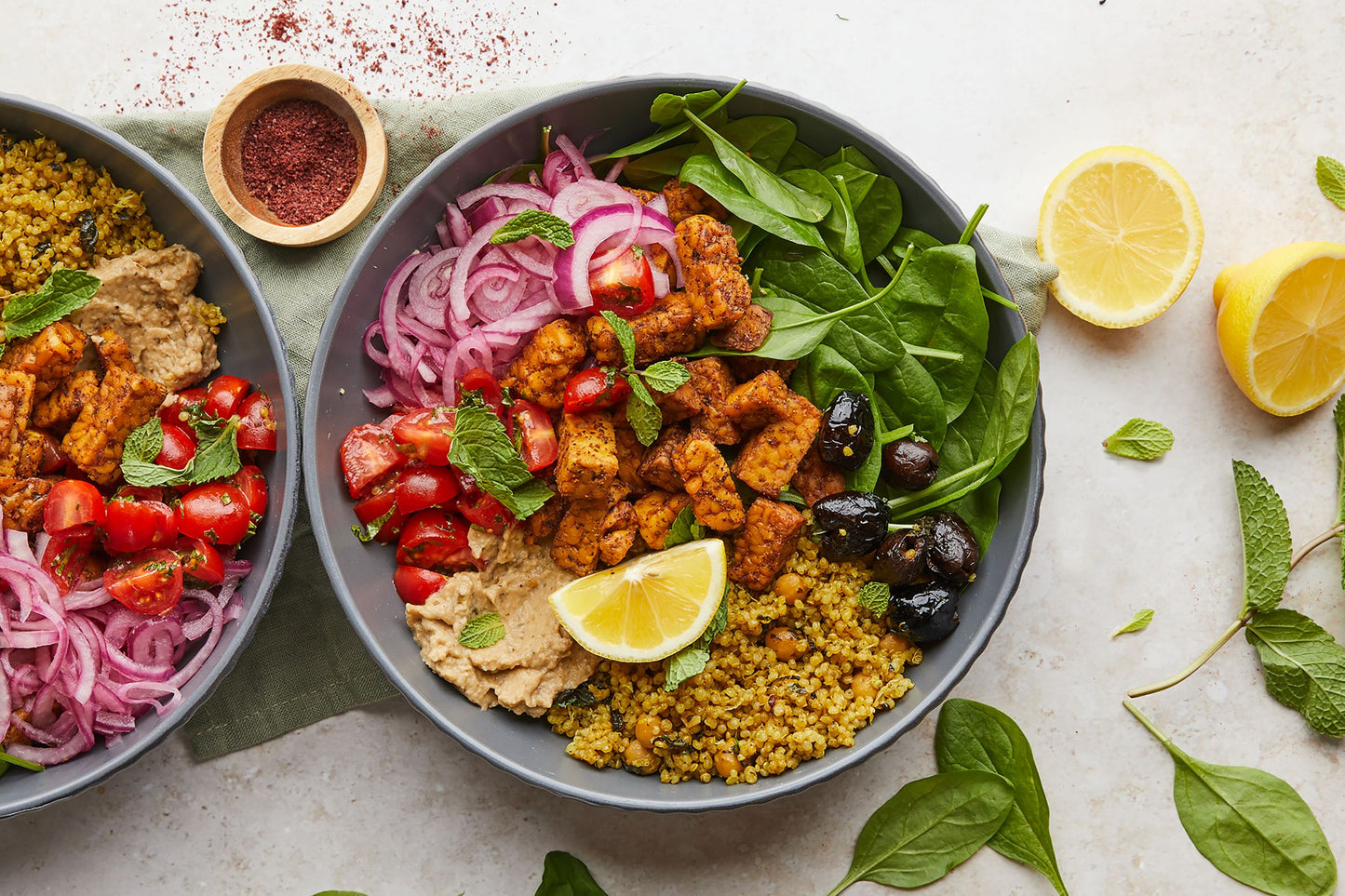 Bowl of Indian style Quinoa, pickled onions, greens and marinated sumac tempeh 