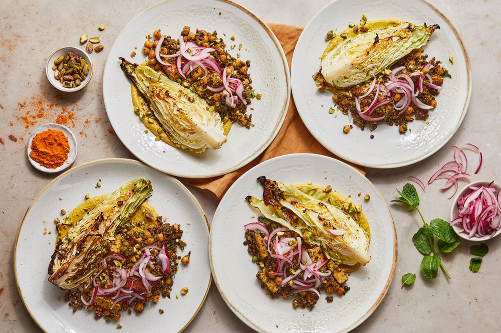 Plates of lentil and quinoa with charred cabbage, pickles and tahini yoghurt 
