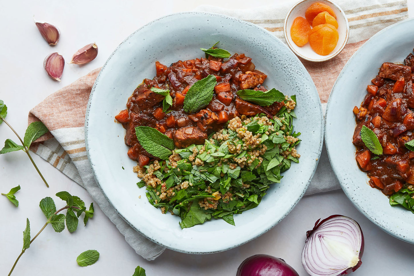 Bowl filled with Tempeh tagine and quinoa mixed with herbs