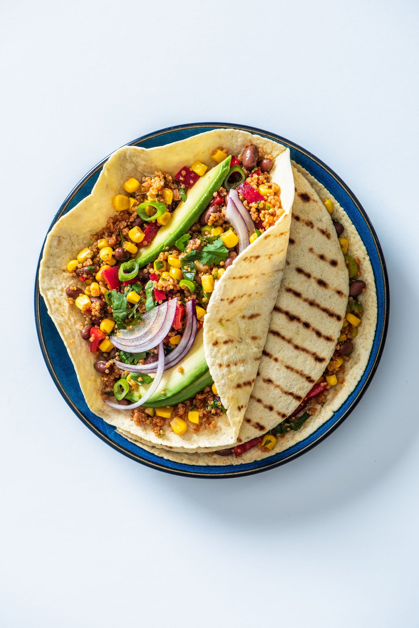 Plate of spicy mexican quinoa in burrito wraps