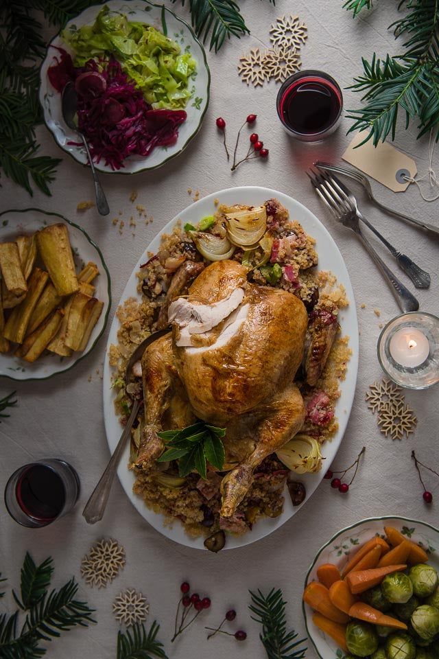 Roasted chicken on a plate of quinoa and vegetables on a Christmas decorated table