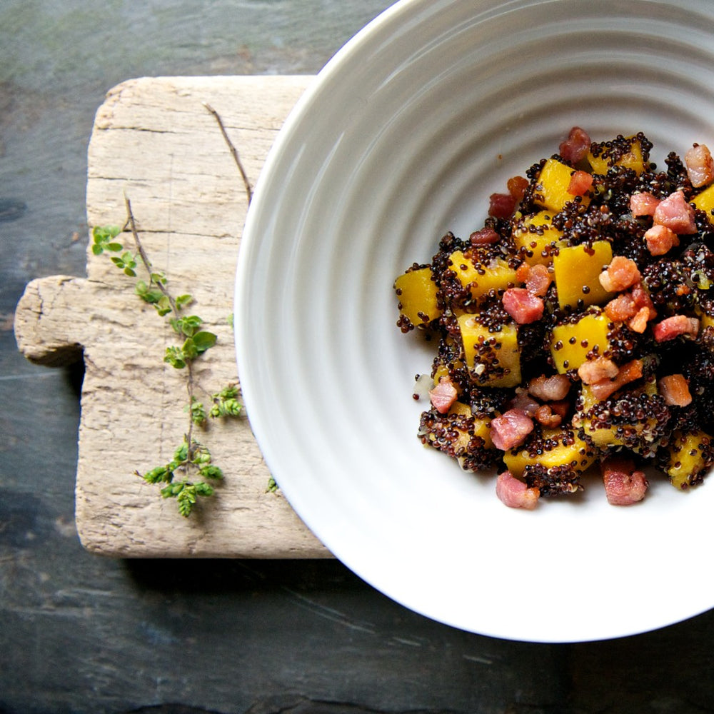 bowl of black quinoa risotto with bacon and butternut squash